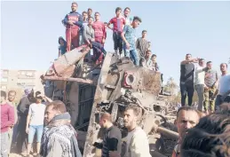  ?? AP ?? People gather around mangled train cars after a deadly collision Friday in southern Egypt.