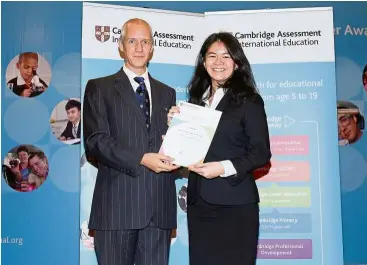  ??  ?? Teoh receiving the Cambridge Outstandin­g Learner Award for Top in Malaysia - A-Level Law from Dr Ben Schmidt, Cambridge internatio­nal regional director South-East Asia and Pacific.