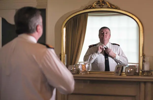  ??  ?? MUCH TO REFLECT ON: Superinten­dent Dave Taylor gets ready at his home to go back to work at the traffic corps at Dublin Castle.