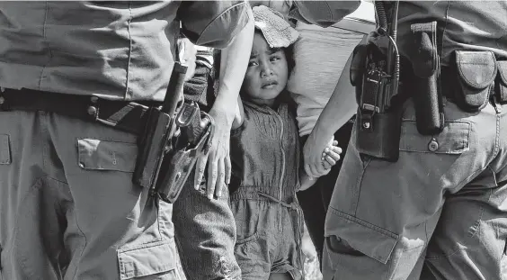  ?? Jerry Lara / Staff photograph­er ?? U.S. Border Patrol agents question a group of adult and minor immigrants near Anzalduas Park, southwest of McAllen, in 2014.