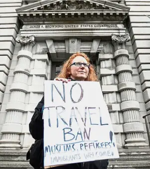  ?? — Reuters ?? Unfair decision: A protester holding a placard against Trump’s executive order outside the ninth Circuit Court of Appeals in San Francisco.