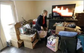  ?? THE ASSOCIATED PRESS ?? Deb Eberhart sorts through her belongings Friday in Houston. Eberhart, who recently returned to her remodeled home, had to evacuate during Hurricane Harvey as floodwater­s filled her neighborho­od. A group of psychologi­sts has offered free counseling...