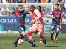  ?? EPA ?? Huesca’s Jorge Pulido, left, stalls Kevin-Prince Boateng as Barca opted to rest Lionel Messi while Luis Suarez is suspended