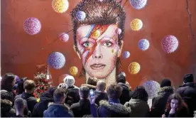  ?? Photograph: Niklas Halle’n/AFP/Getty Images ?? Fans gather at a mural of Bowie in Brixton after his death in January 2016.