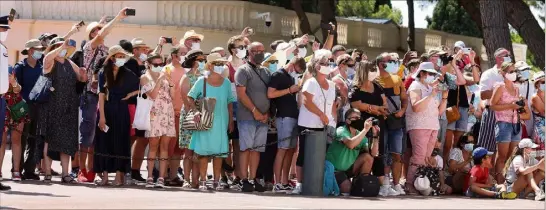  ?? (Photo Cyril Dodergny) ?? Sur la place du Palais, c’est désormais une forêt de touristes masqués qui assiste à la relève de la garde.