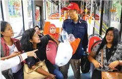 ?? PUJI TYAS/JAWA POS ?? TIDAK PAKAI UANG: Penumpang Suroboyo Bus cukup membawa botol atau gelas plastik bekas sebagai pengganti tiket.