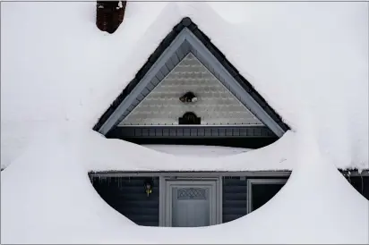  ?? PHOTOS BY JAE C. HONG — THE ASSOCIATED PRESS ?? Snow is piled up on a home in Running Springs on Tuesday.