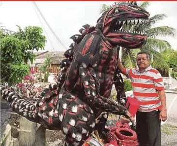  ?? BERNAMA PIC ?? Zazali Iberahim with one of the biggest scupltures he made with used tyres, at his house in Senawang yesterday.