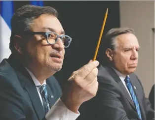  ?? JACQUES BOISSINOT/THE CANADIAN PRESS ?? Horacio Arruda, Quebec’s public health director, responds to reporters during a news conference on Wednesday, along with Premier François Legault, in Quebec City.