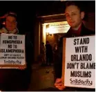  ??  ?? People in Sydney, Australia, at a candleligh­t vigil for victims of the Pulse Nightclub shooting in Orlando