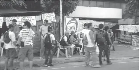  ?? JAY ROMMEL LABRA ?? A militant group displays placards and posters calling for the end of contractua­lization in front of the DOLE-7 office in Gorordo Avenue, Cebu City.