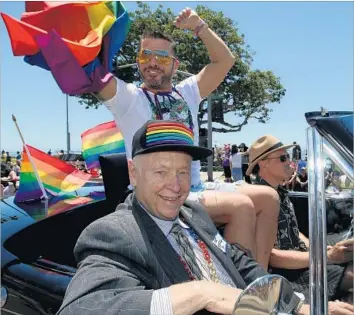  ?? Luis Sinco Los Angeles Times ?? BRUCE NICKERSON, foreground, rides with former client Rory Moroney, center, and Mark De Dubovay in Long Beach’s pride parade. For decades, he’s been the go-to lawyer for gay men accused of lewd conduct.