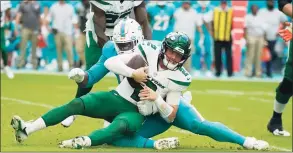  ?? Lynne Sladky / Associated Press ?? Miami Dolphins defensive end Emmanuel Ogbah sacks New York Jets quarterbac­k Zach Wilson (2) during the second half on Sunday in Miami Gardens, Fla.