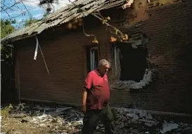  ?? LEO CORREA/AP ?? Taras Logginov, the head of a rapid response unit, walks Monday near the Ukrainian Red Cross Society’s building that was hit during a Russian attack in Sloviansk, Ukraine.