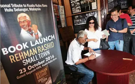  ??  ?? Memories in words: Rehman signing copies of his book ‘Small Town’ during a meet-and-greet session after the book launch in Kuala Kubu Baru.