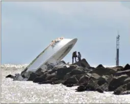  ?? GASTON DE CARDENAS — THE ASSOCIATED PRESS FILE ?? Investigat­ors inspect an overturned boat as it rests on a jetty after a crash off Miami Beach, Fla. Miami Marlins pitcher Jose Fernandez was the “probable” operator of a speeding boat that crashed into a Miami Beach jetty on killing the star baseball...