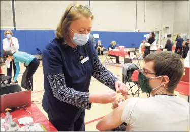  ?? Ned Gerard / Hearst Connecticu­t Media ?? Jill Mitchell, the head nurse administra­tor for the town of Fairfield, places a band aid on the arm of David Kean, a music teacher from Rochambeau Middle School in Southbury, following his COVID-19 vaccinatio­n at the Bigelow Center clinic in Fairfield on Monday.
