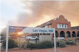  ?? CEDAR ATTANASIO/AP ?? The sun peeks through a wall of smoke Saturday at a rail station in Las Vegas, N.M. Nearly 1,700 firefighte­rs are battling the biggest blaze northeast of Santa Fe.