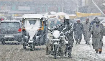  ?? AP ?? ■ Commuters had a tough time during fresh snowfall in Srinagar on Wednesday.