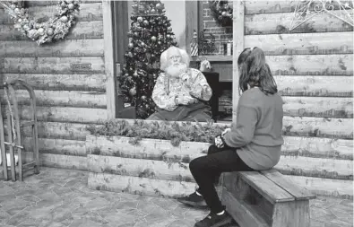  ?? JIM MONE/AP ?? Sid Fletcher, dressed up as Santa Claus, sits behind a barrier as he listens to Kendra Alexander, of St. James, Minnesota, during her visit to The Santa Experience on Nov. 15 at the Mall of America near Minneapoli­s.