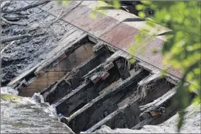  ?? Will Waldron / Times Union ?? A hole is knocked through the dam creating Mount Ida Lake on Friday in Troy. The city is removing part of the dam to slowly lower the lake’s water level.