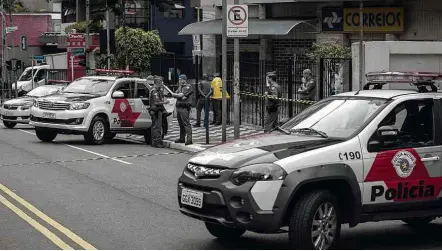  ?? Eduardo Anizelli/Folhapress ?? Policiais diante de agência dos Correios na avenida Angélica, em Higienópol­is (centro), que foi fechada após assalto
