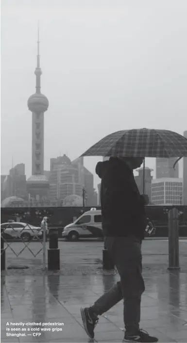  ?? — CFP ?? A heavily-clothed pedestrian is seen as a cold wave grips Shanghai.