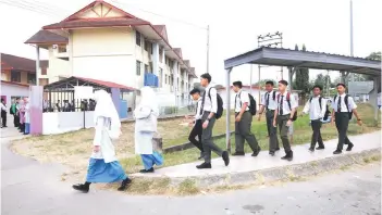  ?? — Bernama photo ?? Students attending school as usual at Sekolah Menengah Kebangsaan (SMK) Kinarut, Papar despite the district being declared as drought disaster.