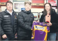  ?? ?? Thomas O’Connell (left) and Orla Cotter presenting medals and a jersey to joint captain, Conor Hegarty in honour of a successful year for St Catherine’s Premier Junior hurlers.