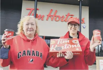  ??  ?? Canadian Rose Kingdom receives a box of donuts from general manger Amy Appleby for her 65th birthday.