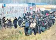  ?? ?? Newly arrived migrants near a barbed wire fence at the Belarusian-polish border