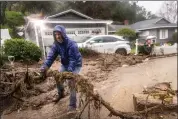  ?? ETHAN SWOPE — THE ASSOCIATED PRESS ?? Jeffrey Raines clears debris from a mudslide at his parent’s home during a rainstorm, Monday, Feb. 5, 2024, in Los Angeles. The second of back-to-back atmospheri­c rivers took aim at Southern California, unleashing mudslides, flooding roadways and knocking out power as the soggy state braced for another day of heavy rains.