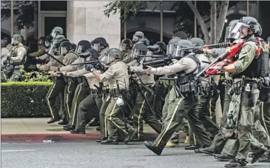  ?? Gina Ferazzi Los Angeles Times ?? RIVERSIDE COUNTY sheriff ’s deputies advance on social justice demonstrat­ors on June 1, 2020.