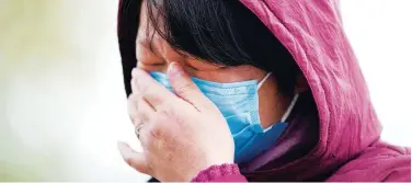  ?? Reuters ?? ↑
A woman cries while talking about not being able to see her mother due to quarantine restrictio­ns on a street in Wuhan on Tuesday.