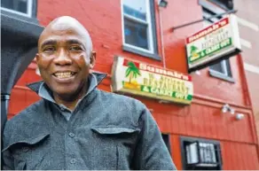  ?? THE ASSOCIATED PRESS ?? Amara Sumah, owner of Sumah’s West African Restaurant, poses outside the restaurant in the Shaw neighborho­od of Washington, D.C. Twenty-five years ago, Sumah and his wife, Isata, immigrated from Sierra Leone. T