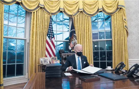  ?? EVAN VUCCI/AP ?? President Joe Biden signs a series of executive orders on Inaugurati­on Day at the White House in Washington.