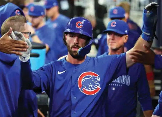  ?? KEVIN C. COX/GETTY IMAGES ?? Cubs shortstop Dansby Swanson gets congratula­tions in the dugout after scoring in the second inning Tuesday against the Braves.