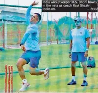  ?? — BCCI ?? India wicketkeep­er M.S. Dhoni bowls in the nets as coach Ravi Shastri looks on.