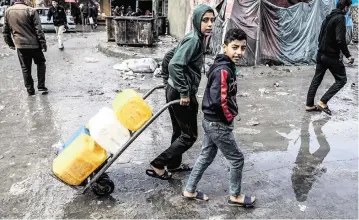  ?? ABED RAHIM KHATIB dpa/sipa USA/USA TODAY NETWORK ?? Children in Rafah in the southern Gaza Strip on Monday travel to try to get drinking water. Hundreds of thousands of Palestinia­ns remain in the north, largely cut off from aid, and hunger-related deaths are occurring, a U.N. agency said..