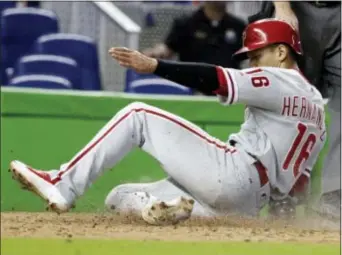  ?? LYNNE SLADKY — THE ASSOCIATED PRESS ?? Second baseman Cesar Hernandez (16) scores on two-run single by Nick Williams in the 12th inning that gave the Phillies a 3-1 victory over the Marlins in Miami Sunday. Hernandez had two hits and drove in the other run for the Phils.