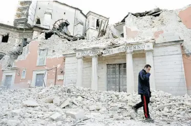  ?? REUTERS FILES ?? An Italian military carabinier­i walks on debris after an earthquake in L’Aquila, Italy.