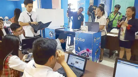  ??  ?? Teachers and students of General Santos City SPED Integrated School demonstrat­e the different things that can be done with the mobile lab donated by Globe Telecom and its customers.