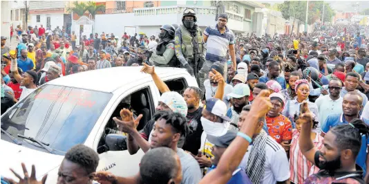  ?? AP ?? People celebrate the arrival of the Protected Areas Security Brigade (BSAP) as they protest for the second consecutiv­e day against Prime Minister Ariel Henry, demanding his ouster, in Port-au-Prince, Haiti yesterday.