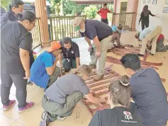 ??  ?? Lok Kawi animal keepers, American zookeepers and APE Malaysia working together to make the bridge ladder.