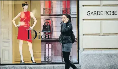  ?? SEAN GALLUP / GETTY ?? Una mujer pasea ante un escaparate de la marca Dior en el centro de Sofía, la capital de Bulgaria