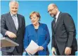  ?? FOTO: DPA ?? Hat etwas in der Hand: Kanzlerin Angela Merkel am Freitag mit Horst Seehofer (CSU) und dem SPD-Vorsitzend­en Martin Schulz.