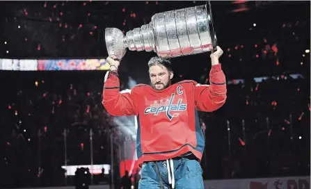  ?? NICK WASS THE ASSOCIATED PRESS ?? Capitals captain Alex Ovechkin lifts the Stanley Cup during the team’s banner-raising ceremony in Washington on Wednesday night. The Capitals showed no signs of a Stanley Cup hangover, beating the Boston Bruins 7-0.