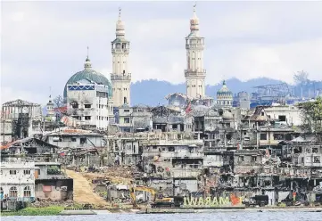  ??  ?? File photo shows a signage of ‘I love Marawi’ seen in front of damaged houses, buildings and a mosque inside a war-torn Marawi city after the Philippine­s announced the end of five months of military operations in a southern city held by pro-Islamic...
