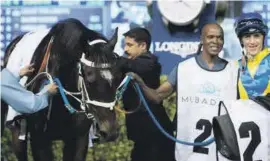  ?? PICTURE: ?? VICTORY RUB-DOWN. The Mike de Kock team, with jockey Christophe Soumillon, after Light The Lights accelerate­d impressive­ly to win the Mubadala Global Trophy over 2000m. It was the stable’s first win at the 2018 Dubai World Cup. The six-year-old gelded...
