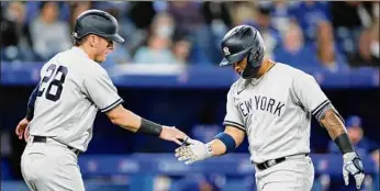  ?? Cole Burston / Getty Images ?? Yankees infielder Gleyber Torres, right, celebrates a two-run home run with Josh Donaldson in their game against Toronto on Monday. Torres drove in all three Yankees runs in the win.